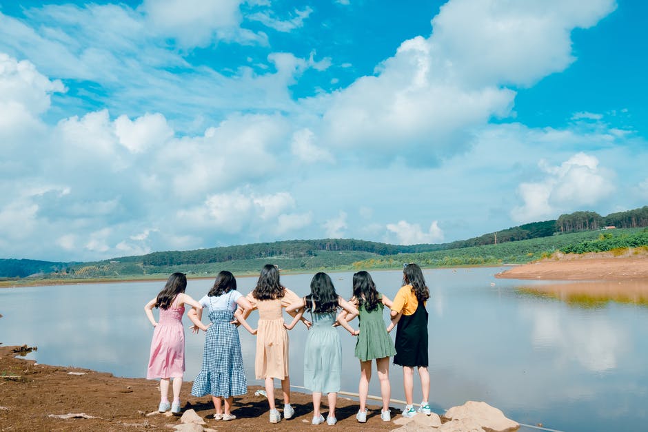 Chicas de espalda admirando lago y naturaleza