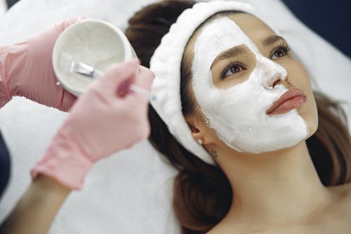 Aplicación de mascarilla facial a una chica