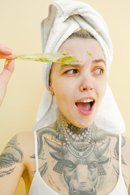 Chica quitando mascarilla facial, preparación de la piel antes del maquillaje