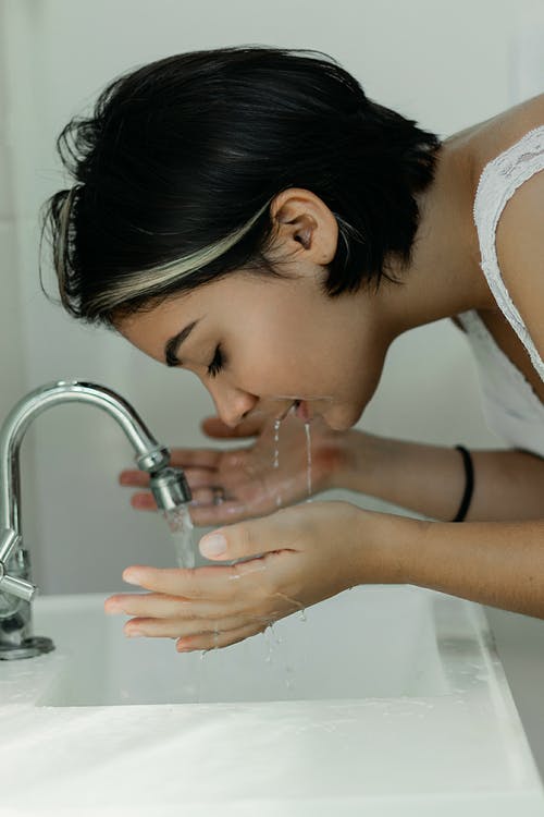 Chica realizando limpieza facial, preparación de la piel antes del maquillaje