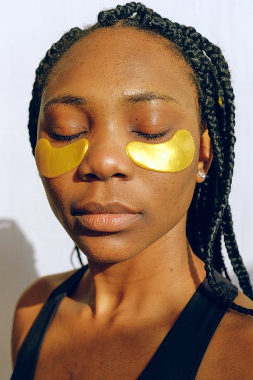 Chica con crema en el contorno de los ojos, preparación de la piel antes del maquillaje