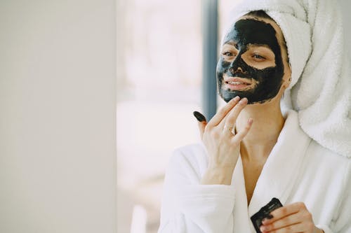 Chica colocando mascarilla facial en el rostro