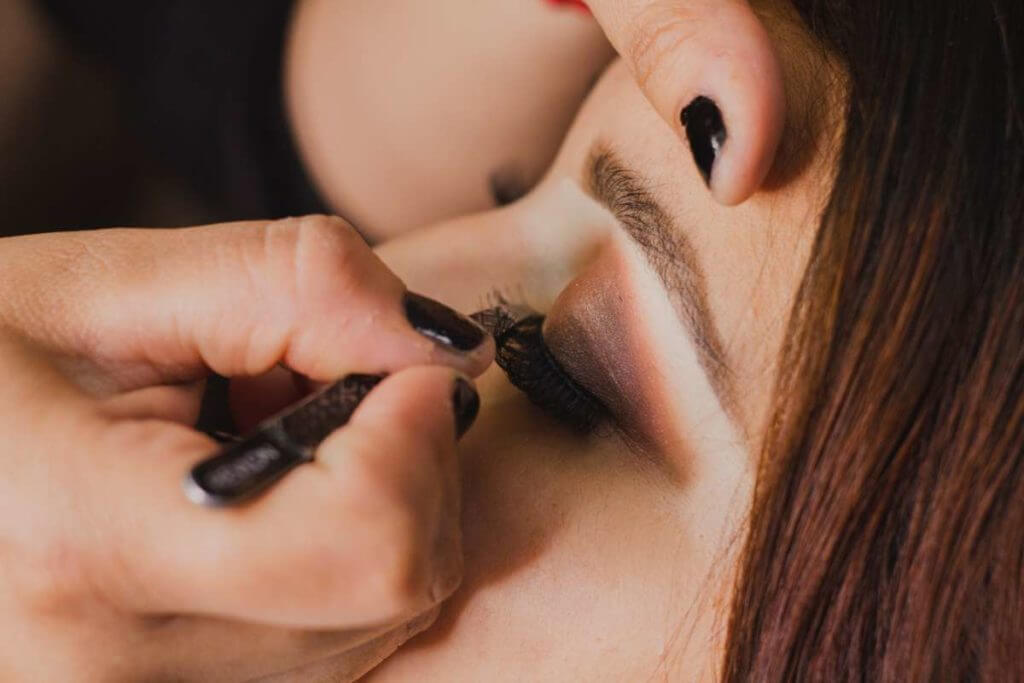 Aplicación de maquillaje en pestañas a una chica