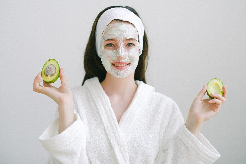 Chica con mascarilla facial de aguacate